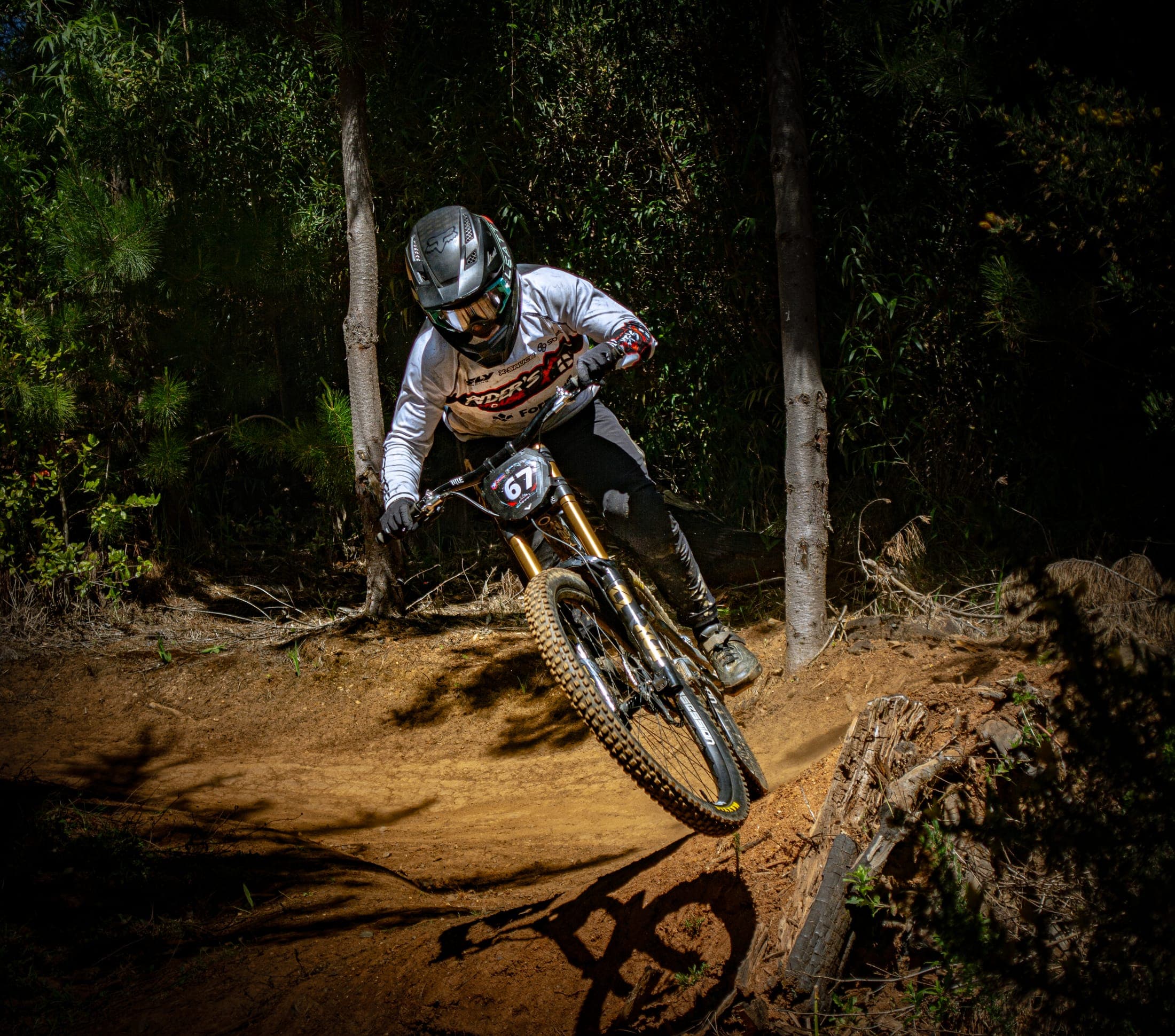 Rider de mountain bike tomando una curva cerrada, dorsal 67 visible